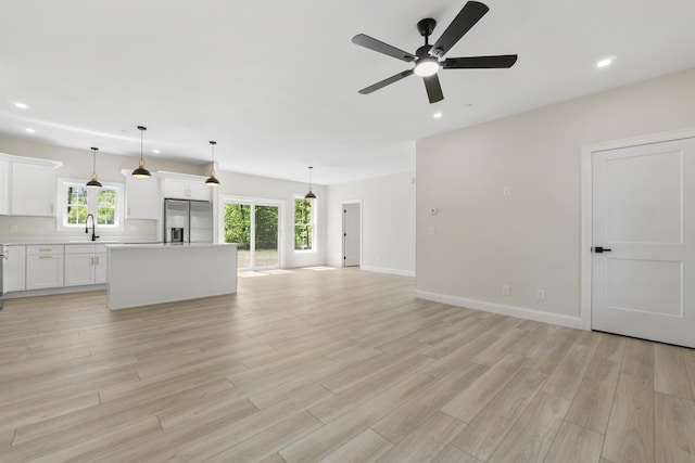 25 Sarah Vaughn Rd, Hollis, ME 04042 - unfurnished living room featuring a ceiling fan, recessed lighting, light wood-type flooring, a sink, and baseboards