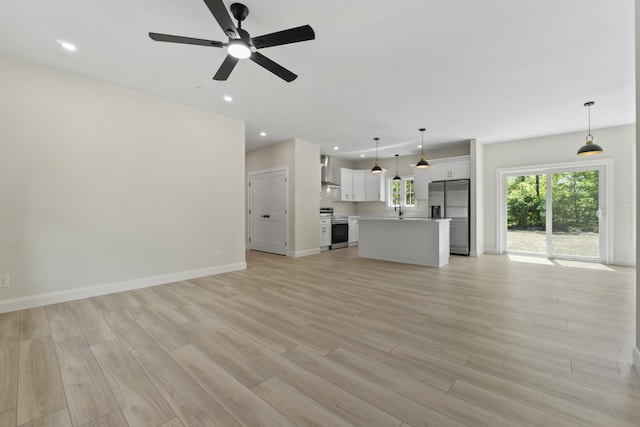 25 Sarah Vaughn Rd, Hollis, ME 04042 - unfurnished living room with light wood-style floors, a ceiling fan, recessed lighting, a sink, and baseboards