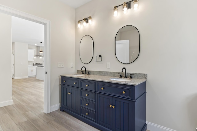 25 Sarah Vaughn Rd, Hollis, ME 04042 - bathroom featuring double vanity, baseboards, and wood finished floors