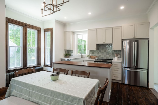 205 Beach St, Saco, ME 04072 - kitchen featuring stainless steel appliances, dark wood-style flooring, backsplash, a chandelier, and crown molding