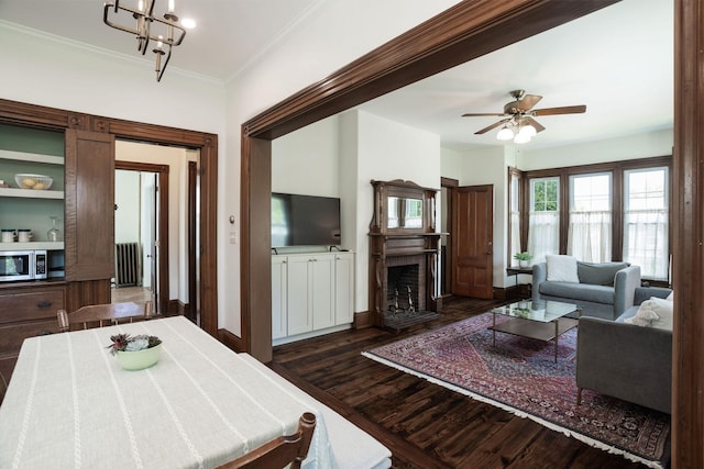205 Beach St, Saco, ME 04072 - living area with dark wood finished floors, radiator heating unit, a ceiling fan, a fireplace with flush hearth, and baseboards