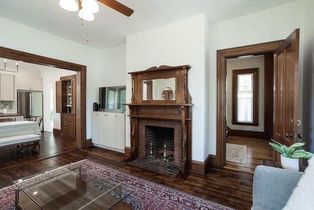 205 Beach St, Saco, ME 04072 - living room with a ceiling fan, dark wood-style floors, a brick fireplace, and baseboards