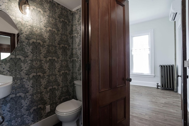 205 Beach St, Saco, ME 04072 - half bath featuring radiator, an AC wall unit, wood finished floors, toilet, and baseboards