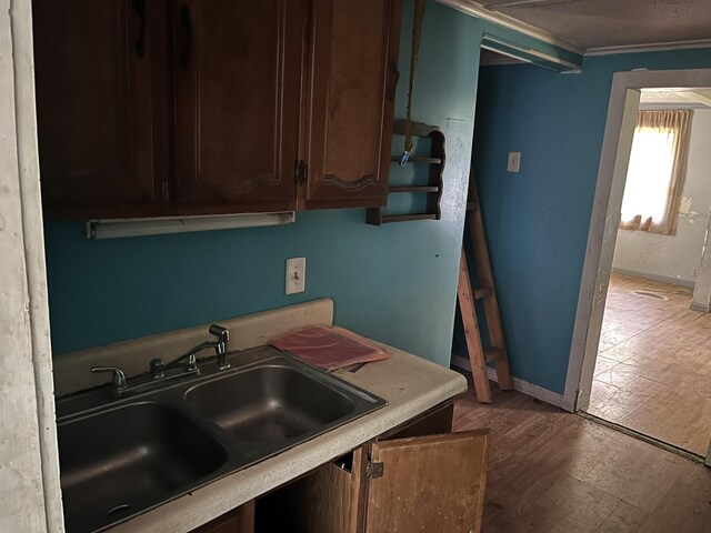 700 Warren Hill Rd, Palmyra, ME 04965 - kitchen featuring light countertops, crown molding, dark brown cabinets, and light wood-style floors