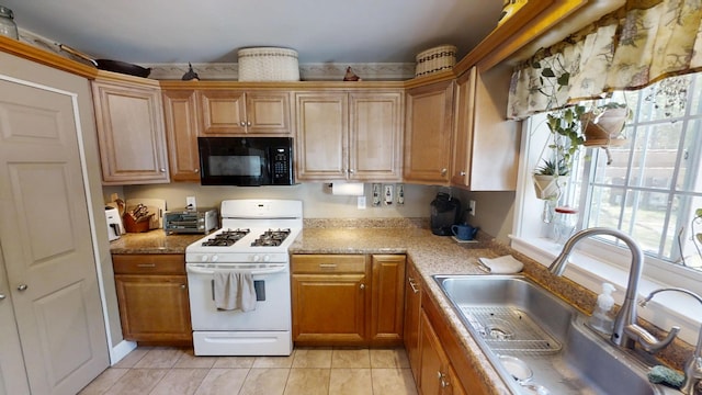 34 Sandy Acres Dr, Sullivan, ME 04664 - kitchen featuring black microwave, white gas range oven, light tile patterned floors, and brown cabinetry