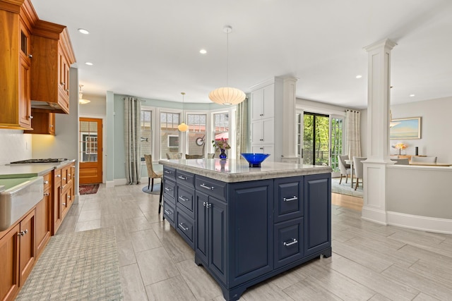 38 Darcy Rd, York, ME 03909 - kitchen featuring ornate columns, recessed lighting, brown cabinetry, and a center island