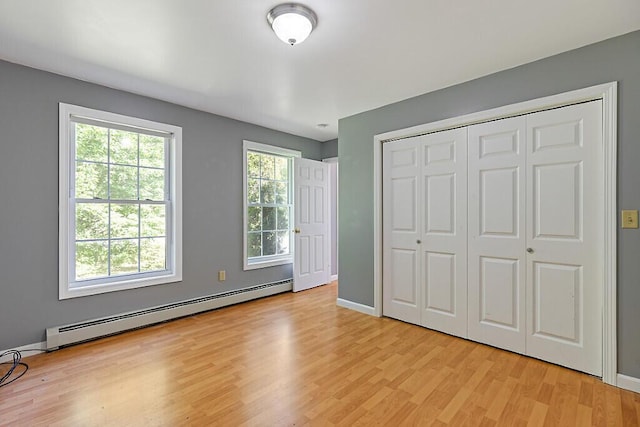 40 Guptill Rd, Belgrade, ME 04917 - unfurnished bedroom with baseboard heating, light wood-style floors, multiple windows, and a closet