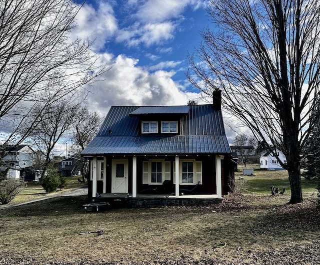 33 Washington St, Caribou, ME 04736 - view of front of house with a chimney, metal roof, and a porch