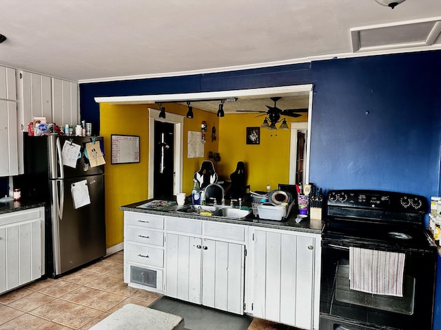 33 Washington St, Caribou, ME 04736 - kitchen featuring black range with electric cooktop, a sink, freestanding refrigerator, dark countertops, and light tile patterned floors