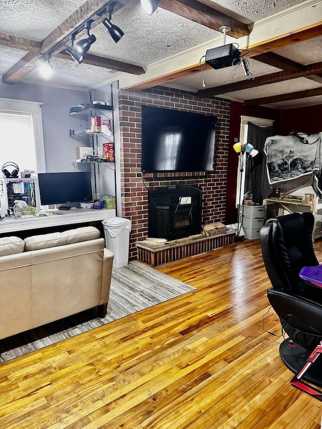 33 Washington St, Caribou, ME 04736 - living area featuring hardwood / wood-style floors, beamed ceiling, a textured ceiling, and a fireplace
