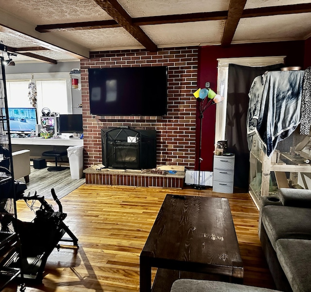 33 Washington St, Caribou, ME 04736 - living room featuring hardwood / wood-style floors, beam ceiling, an office area, a brick fireplace, and a ceiling fan