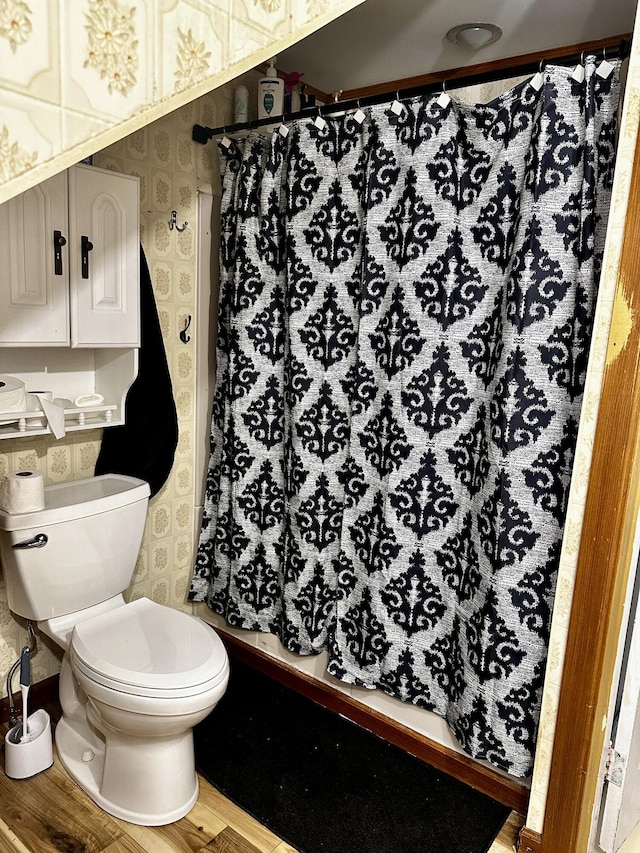 33 Washington St, Caribou, ME 04736 - full bath featuring wallpapered walls, wood finished floors, toilet, and a shower with shower curtain