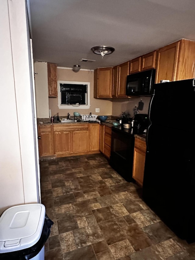 33 Washington St, Caribou, ME 04736 - kitchen featuring black appliances, dark countertops, brown cabinetry, stone finish floors, and a sink