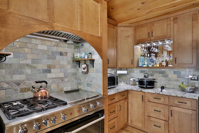 500 Black Point Rd, Beaver Cove, ME 04441 - kitchen featuring high end range, decorative backsplash, and light stone counters