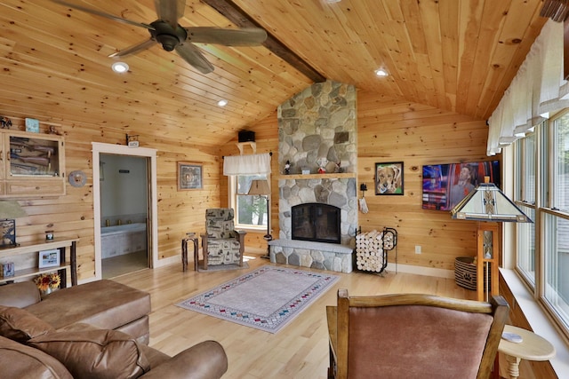 500 Black Point Rd, Beaver Cove, ME 04441 - living room with vaulted ceiling, wood finished floors, wooden walls, a fireplace, and ceiling fan