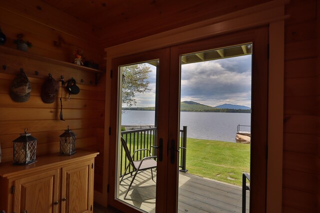 500 Black Point Rd, Beaver Cove, ME 04441 - doorway to outside featuring a water view, french doors, light wood finished floors, and wood walls