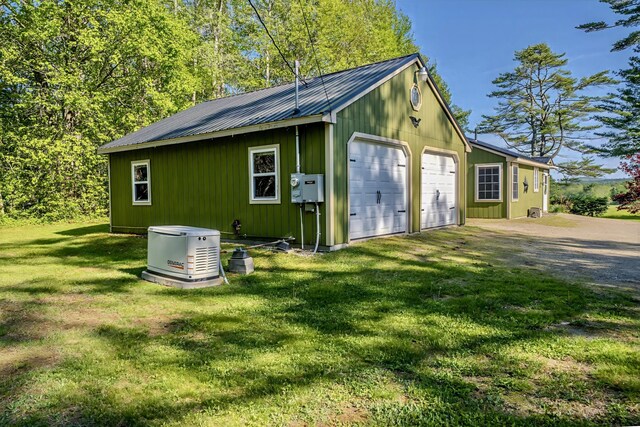 3 Reeds Ln, Belfast, ME 04915 - view of side of home featuring a garage, metal roof, an outbuilding, a yard, and board and batten siding