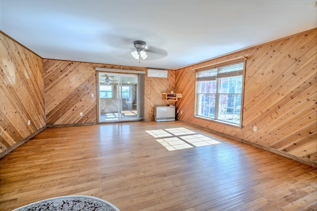 3 Reeds Ln, Belfast, ME 04915 - unfurnished living room with a ceiling fan, healthy amount of natural light, wood walls, a wall mounted AC, and light wood-type flooring