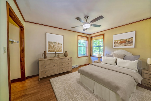 3 Reeds Ln, Belfast, ME 04915 - bedroom with wood finished floors, baseboards, crown molding, a ceiling fan, and a baseboard radiator