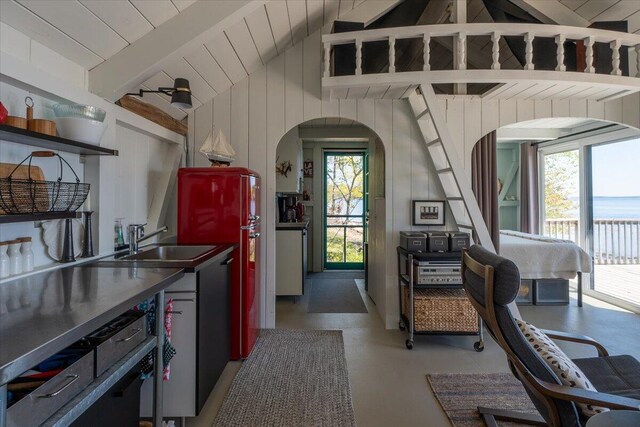459 Main Rd, Islesboro, ME 04848 - kitchen featuring arched walkways, wooden walls, freestanding refrigerator, and dark countertops