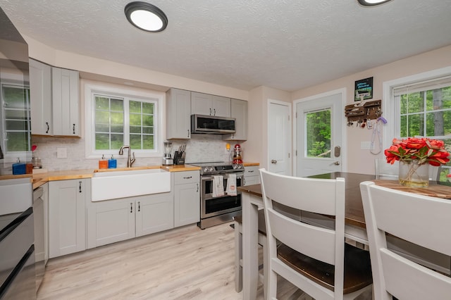 68 Lone Pine Rd, Waterboro, ME 04061 - kitchen featuring appliances with stainless steel finishes, a sink, butcher block countertops, light wood-type flooring, and tasteful backsplash