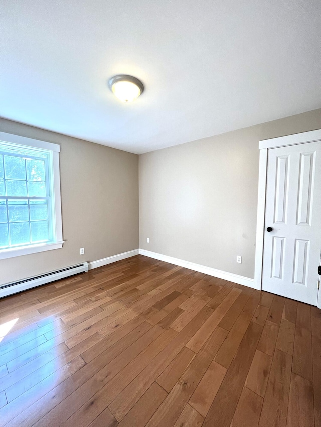 52 Peary Ter, South Portland, ME 04106 - empty room with dark wood-style floors, a baseboard heating unit, and baseboards