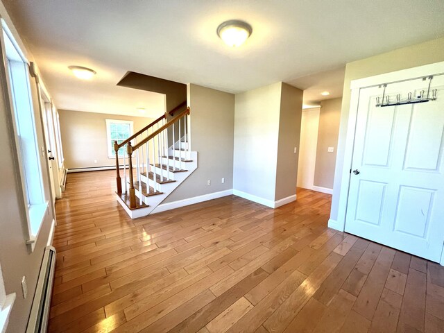 52 Peary Ter, South Portland, ME 04106 - foyer with a baseboard heating unit, stairway, baseboards, and wood finished floors