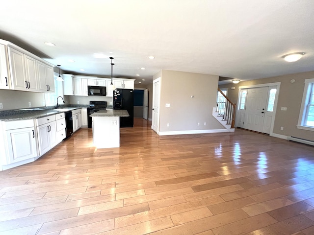 52 Peary Ter, South Portland, ME 04106 - kitchen with black appliances, open floor plan, light wood-type flooring, baseboards, and recessed lighting
