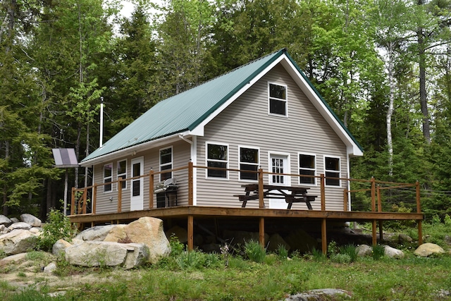 121 Loop Rd, Lincoln, ME 04457 - back of property featuring a deck, metal roof, and a wooded view