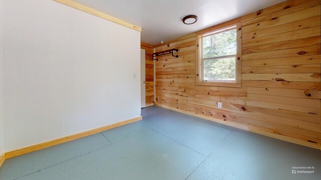 121 Loop Rd, Lincoln, ME 04457 - empty room featuring concrete flooring, baseboards, and wooden walls