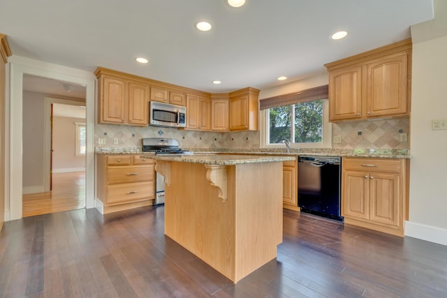 61 Carlyle Rd, Portland, ME 04103 - kitchen with appliances with stainless steel finishes, a kitchen breakfast bar, light stone countertops, dark wood finished floors, and recessed lighting