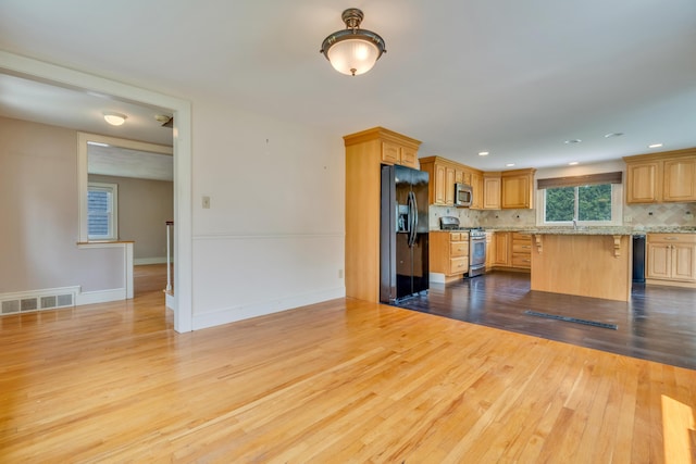 61 Carlyle Rd, Portland, ME 04103 - kitchen featuring stainless steel appliances, wood finished floors, decorative backsplash, a kitchen breakfast bar, and recessed lighting