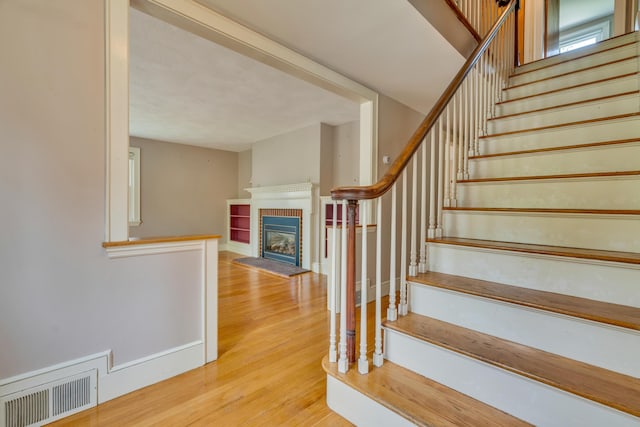 61 Carlyle Rd, Portland, ME 04103 - staircase with wood finished floors and a tile fireplace