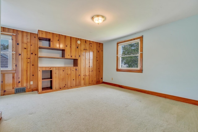 61 Carlyle Rd, Portland, ME 04103 - unfurnished living room featuring carpet, baseboards, and wooden walls