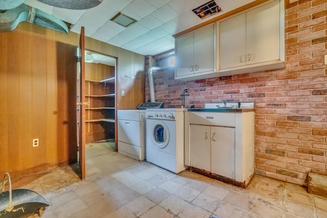 61 Carlyle Rd, Portland, ME 04103 - laundry area featuring cabinet space, washing machine and dryer, wood walls, light flooring, and a wood stove
