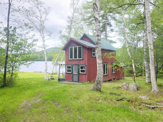 16 Mellen Ln, Wilton, ME 04294 - view of property exterior featuring a lawn, metal roof, and a water view