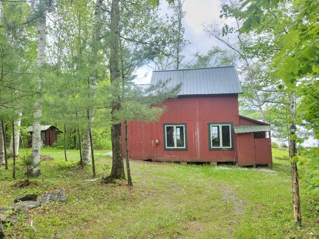 16 Mellen Ln, Wilton, ME 04294 - view of property exterior featuring an outbuilding, metal roof, and a yard