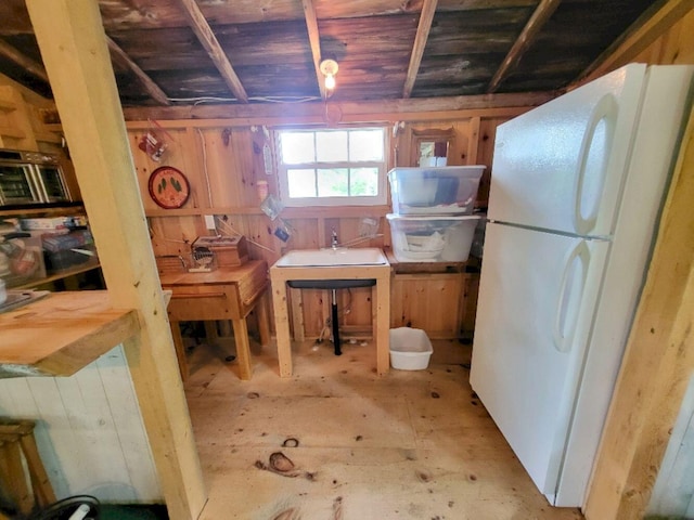 16 Mellen Ln, Wilton, ME 04294 - kitchen with freestanding refrigerator, wood ceiling, a sink, and wood walls