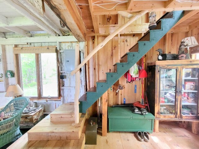 16 Mellen Ln, Wilton, ME 04294 - stairs with electric panel, hardwood / wood-style flooring, and wood walls