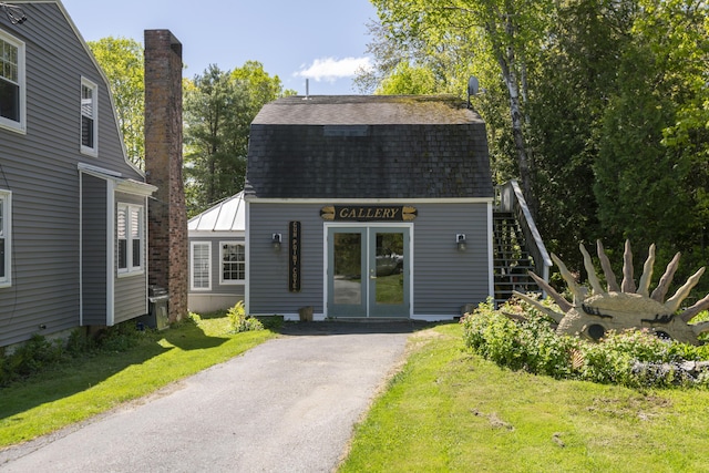 1241 Harpswell Islands Rd, Harpswell, ME 04079 - view of front of home with a shingled roof, a gambrel roof, a front lawn, driveway, and stairway