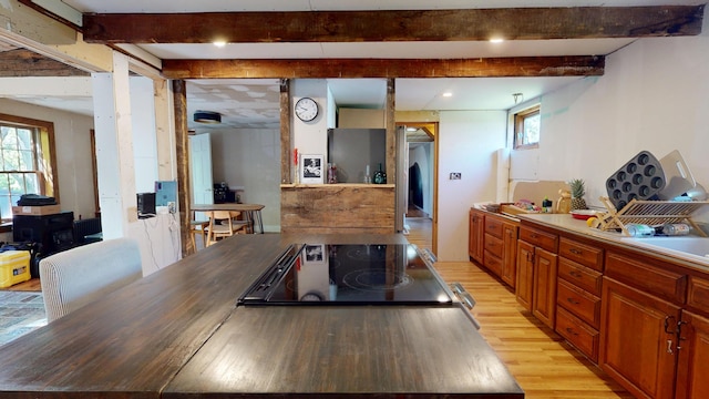 99 Kenduskeag Ave, Bangor, ME 04401 - kitchen with light wood finished floors, beamed ceiling, cooktop, and brown cabinetry