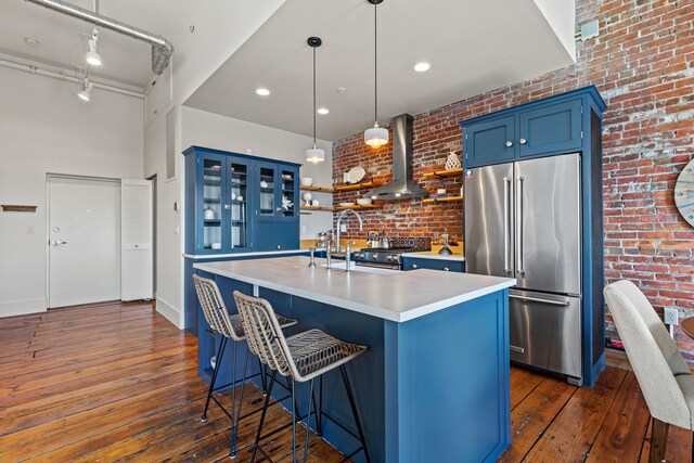 15 Brown St Unit 405, Portland, ME 04101 - kitchen with high end appliances, blue cabinetry, wall chimney exhaust hood, dark wood-type flooring, and light countertops