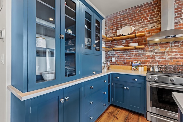 15 Brown St Unit 405, Portland, ME 04101 - kitchen featuring blue cabinets, wall chimney exhaust hood, gas stove, brick wall, and glass insert cabinets