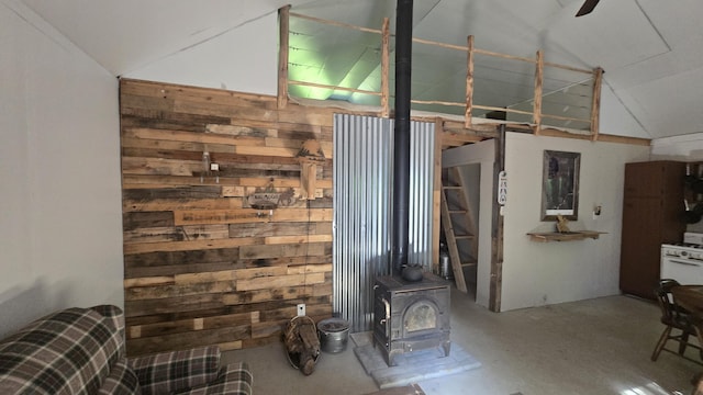 55.4AC Fire Rd, Linneus, ME 04730 - unfurnished living room featuring a wood stove, wooden walls, high vaulted ceiling, concrete flooring, and a ceiling fan
