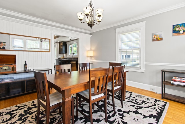 797 Main St, South Portland, ME 04106 - dining area with crown molding, a chandelier, wood finished floors, and baseboards