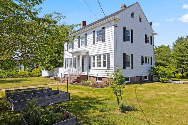 797 Main St, South Portland, ME 04106 - colonial home featuring a garden, a chimney, and a front lawn