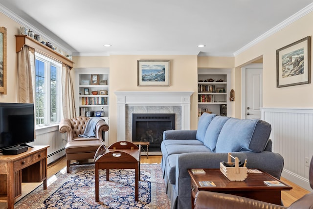 14 Merriconeag Ln, Harpswell, ME 04079 - living area featuring baseboard heating, built in features, light wood-style floors, ornamental molding, and a tile fireplace