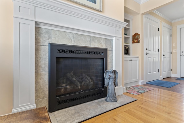14 Merriconeag Ln, Harpswell, ME 04079 - detailed view of crown molding, wood finished floors, a tiled fireplace, built in shelves, and baseboards