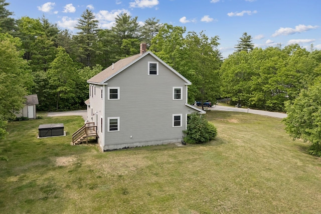 26 Serenity Ln, Topsham, ME 04086 - view of side of property featuring a chimney, an outdoor structure, a yard, and a forest view