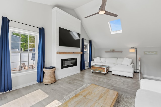 27 Seaside Ave, Saco, ME 04072 - living room featuring a ceiling fan, lofted ceiling, a skylight, wood finished floors, and a large fireplace